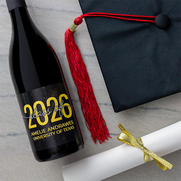 Custom labeled graduation 2026 wine bottle with cap and diploma on marble table.