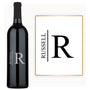 Custom wine bottle engraved with RUSSELL next to a matching black and white framed print.