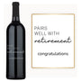 A custom engraved wine bottle labeled Pairs Well With Retirement next to a matching decorative sign.