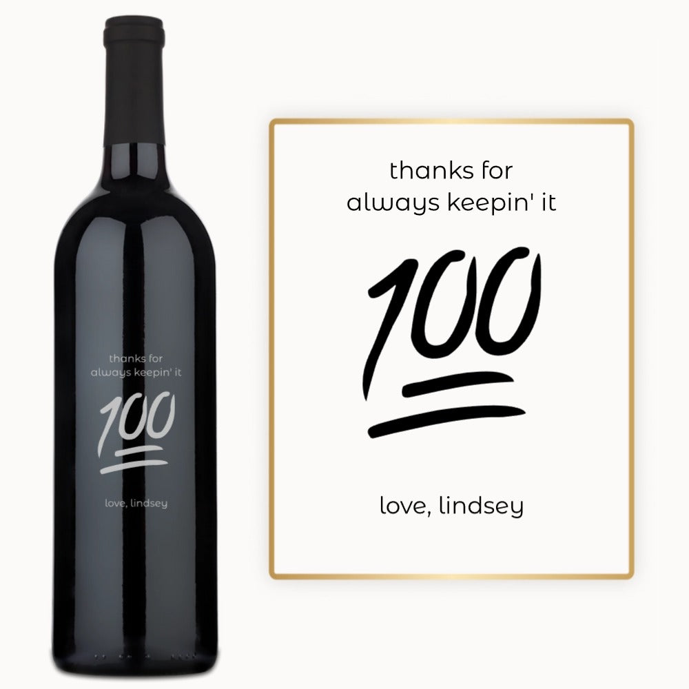 A wine bottle engraved with Keep It 100 next to a matching card, both arranged as a birthday gift set.