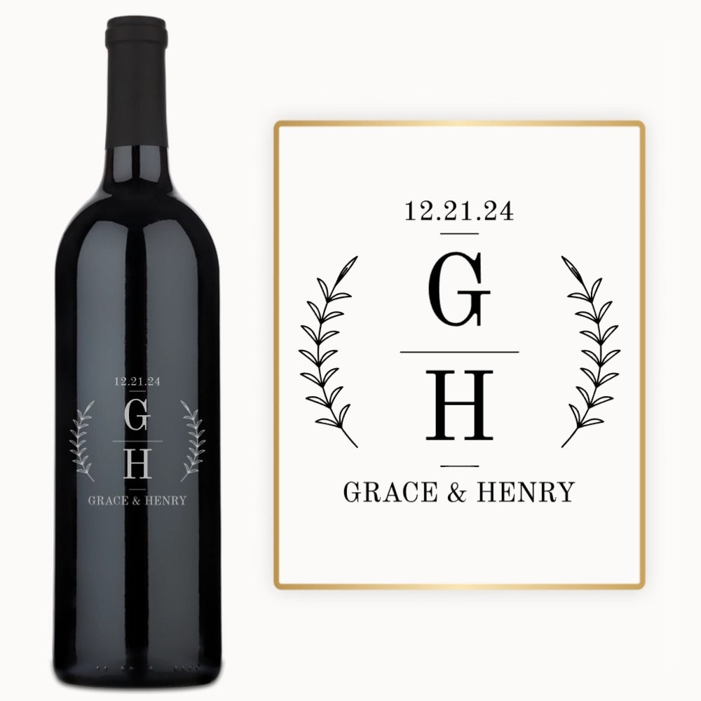A wine bottle engraved with “12.21.24, G H, Grace & Henry” and decorated with leafy accents.