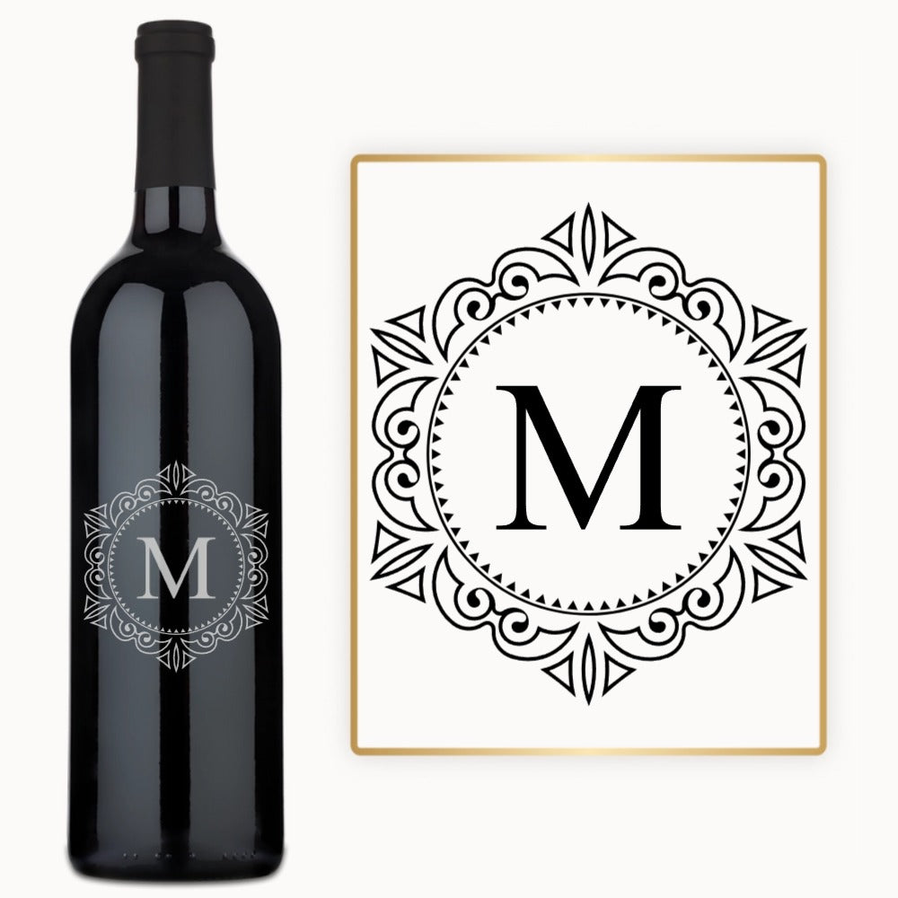 A wine bottle with a circular M monogram engraved on the label next to a matching card.