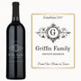 A custom engraved wine bottle sits next to a matching sign displaying the same monogram.