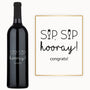 Bottle of wine with Sip Sip Hooray engraved on the label, next to a festive wine glass with decorative art.