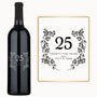 A wine bottle labeled 25 Years July 8, 1999 with a floral wreath design on the front.