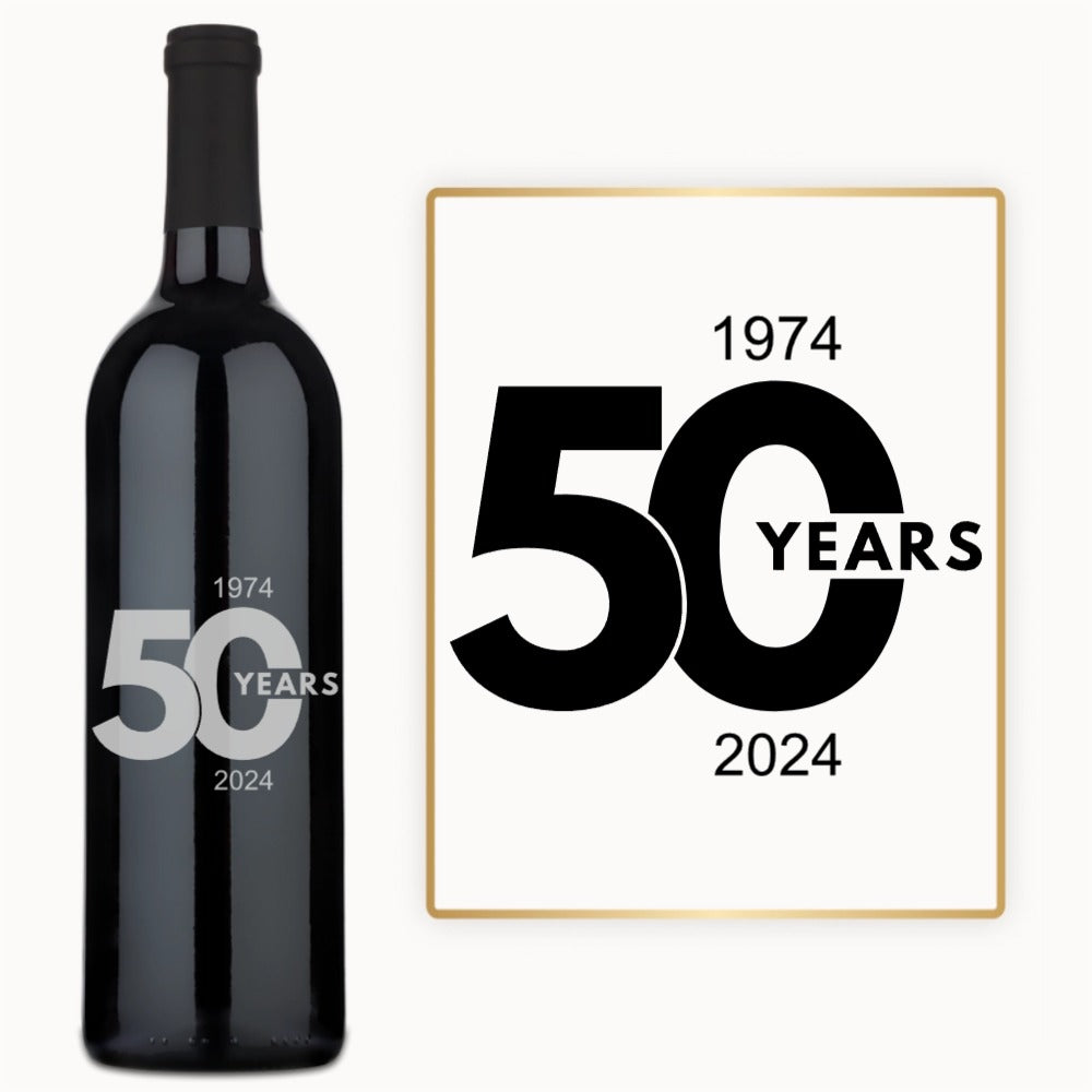 A wine bottle labeled 50 Year Milestone with engraved years 1974–2024 celebrates a 50th anniversary.