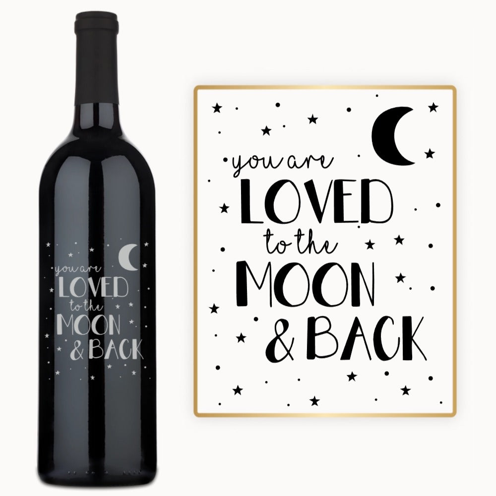 A wine bottle engraved with stars, a crescent moon, and the phrase “You are loved.”.