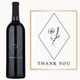 A wine bottle with a gold and black Thank You label featuring a simple floral design.