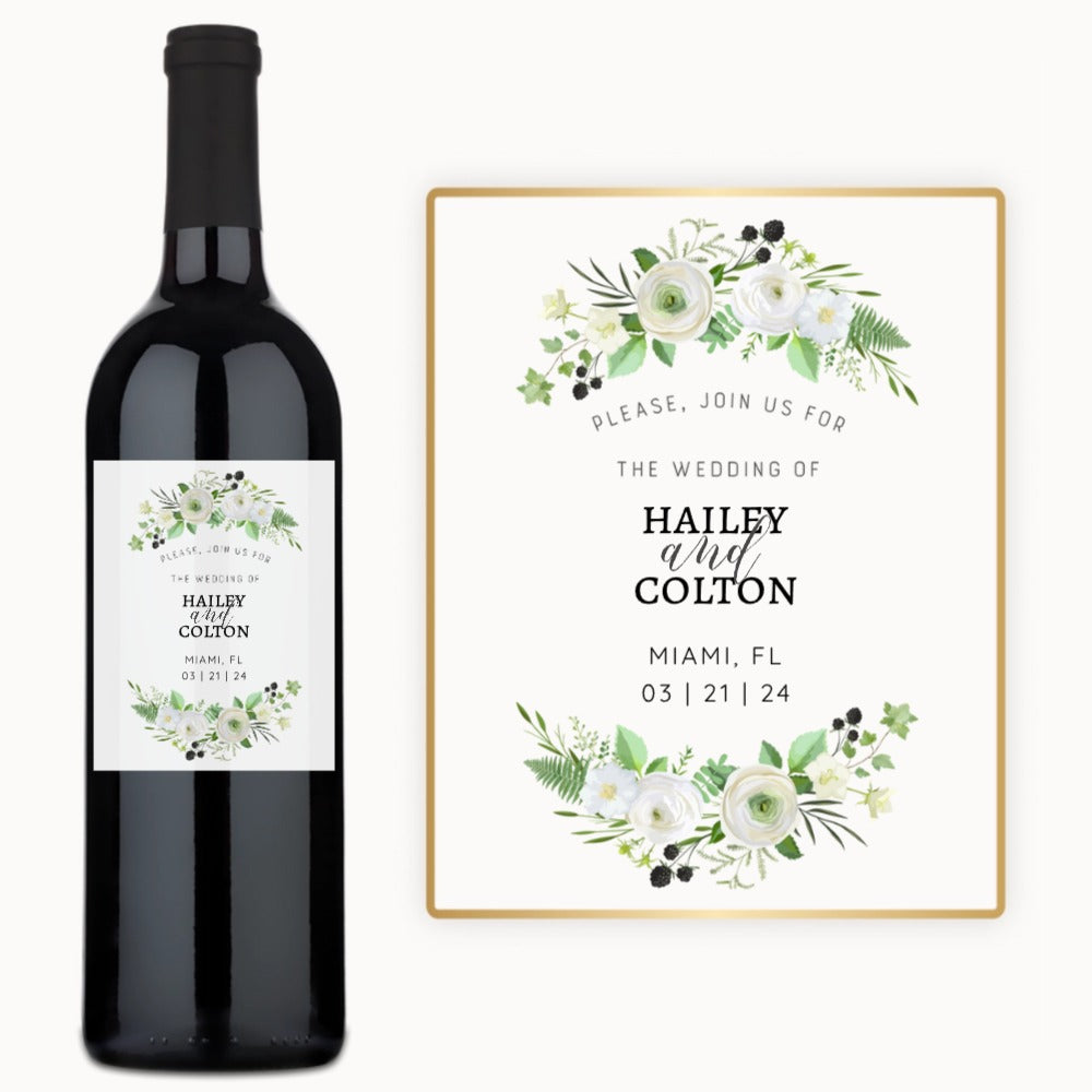 A wine bottle with a custom label showing white flowers, greenery, and the names Hailey & Colton.
