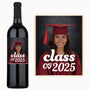 A wine bottle with a custom label showing a smiling graduate in cap and gown, and the class year.