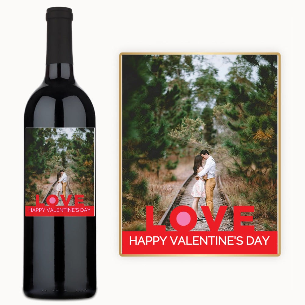A wine bottle with a label showing a couple embracing on a wooded path, accompanied by a matching card.