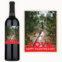 A wine bottle with a label showing a couple embracing on a wooded path, accompanied by a matching card.