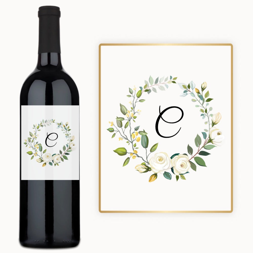 A wine bottle with a custom label featuring a floral wreath and monogram design.