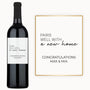 A bottle of wine with a custom label reading “Pairs Well With a New Home,” alongside the names Max & Mia.
