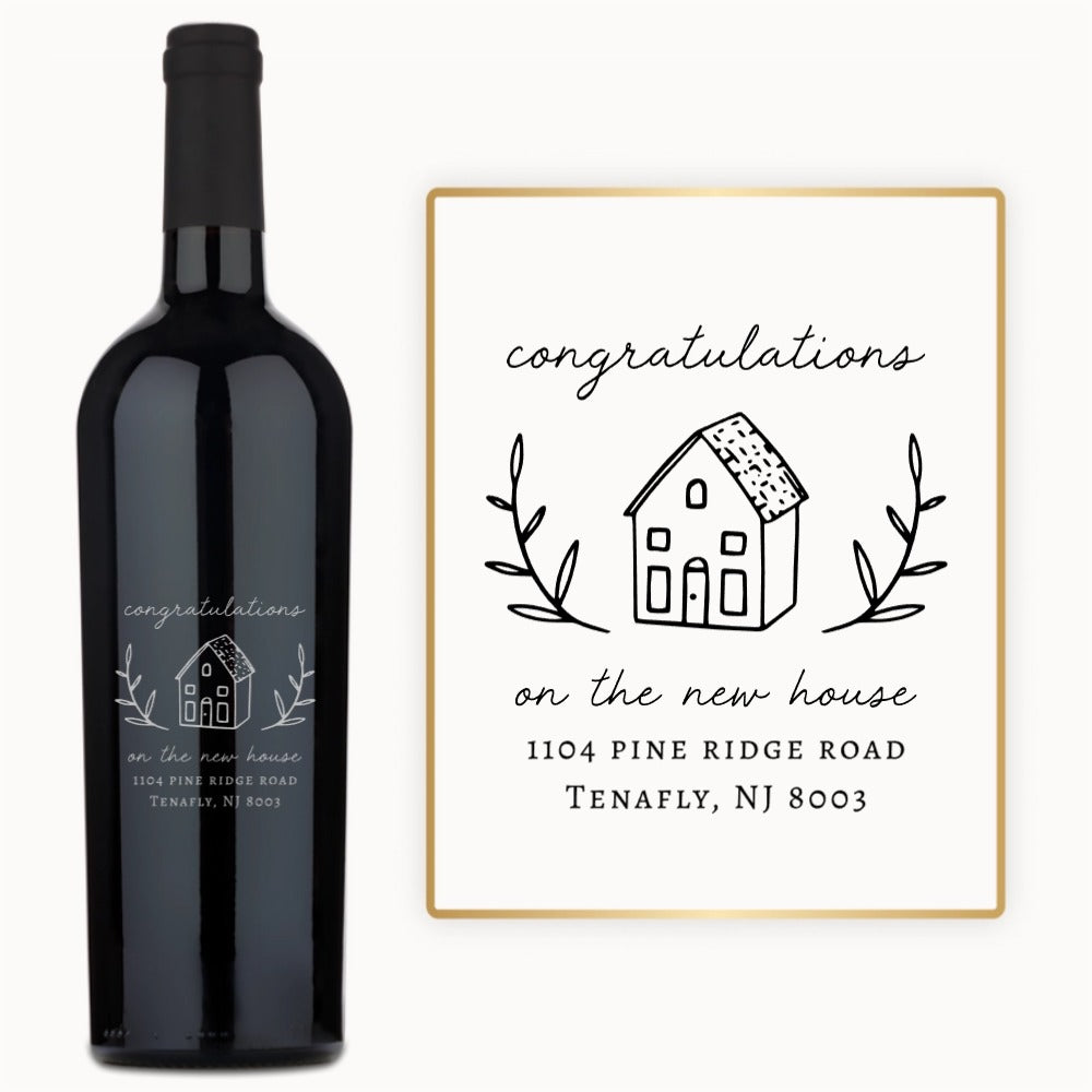 A wine bottle labeled Welcome Home Estate with a card reading, “Congrats on the new house, 1104 Pine Ridge Rd, Tenafly, NJ.”.