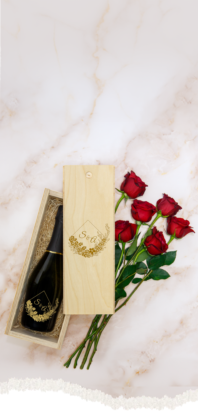 Bottle of custom champagne and red roses on a marble surface