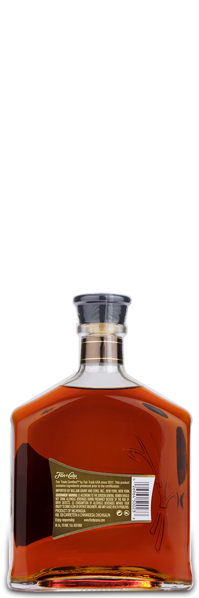 A rectangular Flor de Cana 18 Year Rum bottle with a black cap and engraved label, shown from the back.