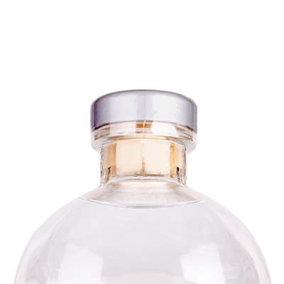 Clear skull-shaped bottle with a silver cap on a white background