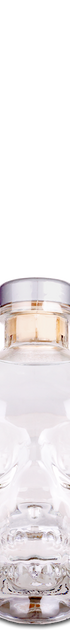 Clear skull-shaped bottle with a silver cap on a white background