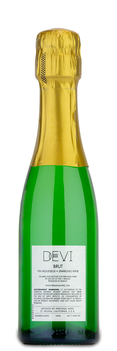 Small green glass bottle of Devi Blanc de Blancs sparkling brut with gold foil top and a simple white label.