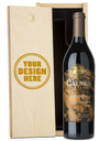 A bottle of Caymus Vineyards California Cabernet Sauvignon next to a light wood presentation box with a customizable engraving design that reads 'YOUR DESIGN HERE'.