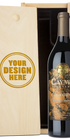 A bottle of Caymus Vineyards California Cabernet Sauvignon next to a light wood presentation box with a customizable engraving design that reads 'YOUR DESIGN HERE'.