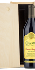 A bottle of Caymus Vineyards Cabernet Sauvignon Napa Valley next to its light natural wood presentation box on a white background.
