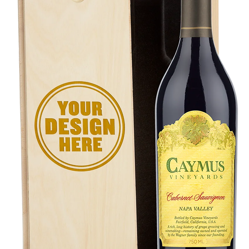 A bottle of Caymus Vineyards Cabernet Sauvignon Napa Valley red wine shown next to a light wood presentation box with a customizable design that reads 'YOUR DESIGN HERE'.