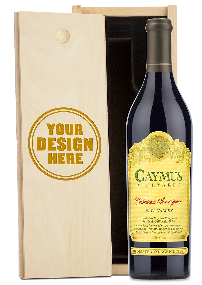 A bottle of Caymus Vineyards Cabernet Sauvignon Napa Valley red wine shown next to a light wood presentation box with a customizable design that reads 'YOUR DESIGN HERE'.