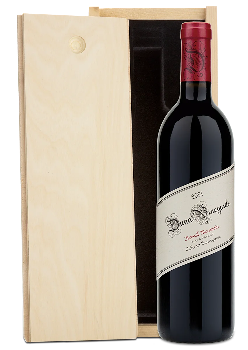 A bottle of 2021 Dunn Vineyards Howell Mountain Cabernet Sauvignon with a plain wooden wine box.