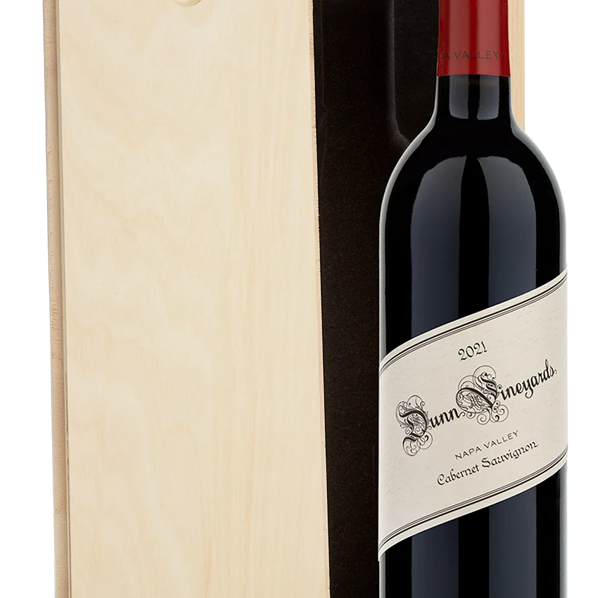 A bottle of 2021 Dunn Vineyards Napa Valley Cabernet Sauvignon with a plain wooden wine box.