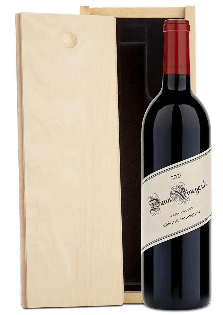 A bottle of 2021 Dunn Vineyards Napa Valley Cabernet Sauvignon with a plain wooden wine box.