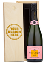 A Veuve Clicquot champagne bottle in a wooden box engraved with Your Design Here on the lid.