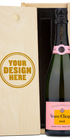 A Veuve Clicquot rose champagne bottle in a wooden box engraved with Your Design Here on the lid.
