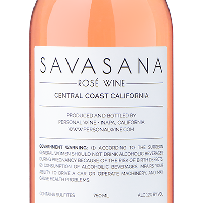 A bottle of Savasana California Rosé with a pink hue and label reading The Doxie Rescue | Lukas Sam.