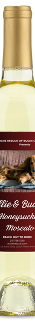 A wine bottle labeled Doxie Rescue | Willie & Buddys Honeysuckle Moscato by personalwine, with a dachshund on a rug.