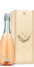 A wine bottle with a floral label alongside a wooden box engraved with matching floral designs.