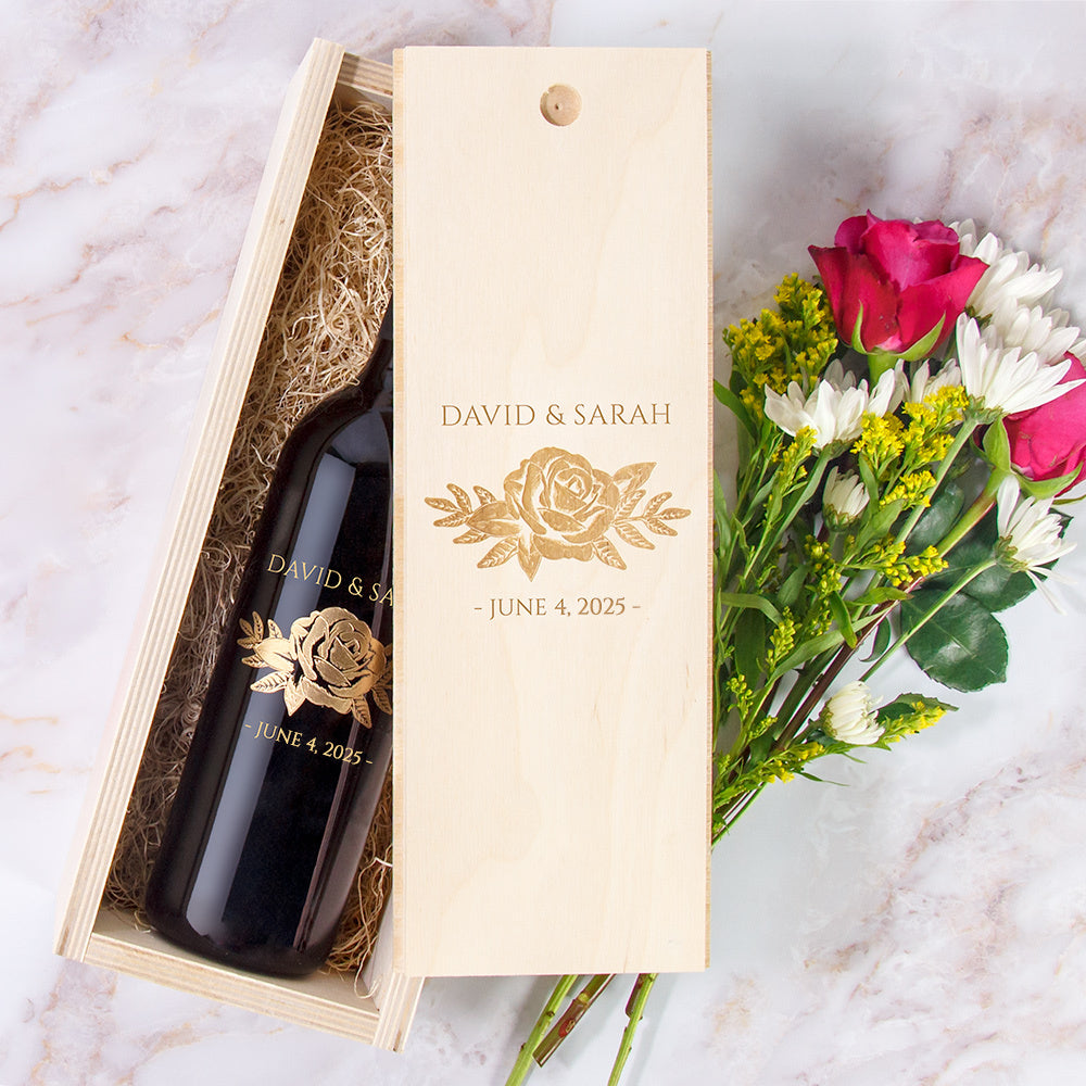 Custom engraved wine and wood box labeled David & Sarah - June 4, 2025 next to a bouquet of flowers.