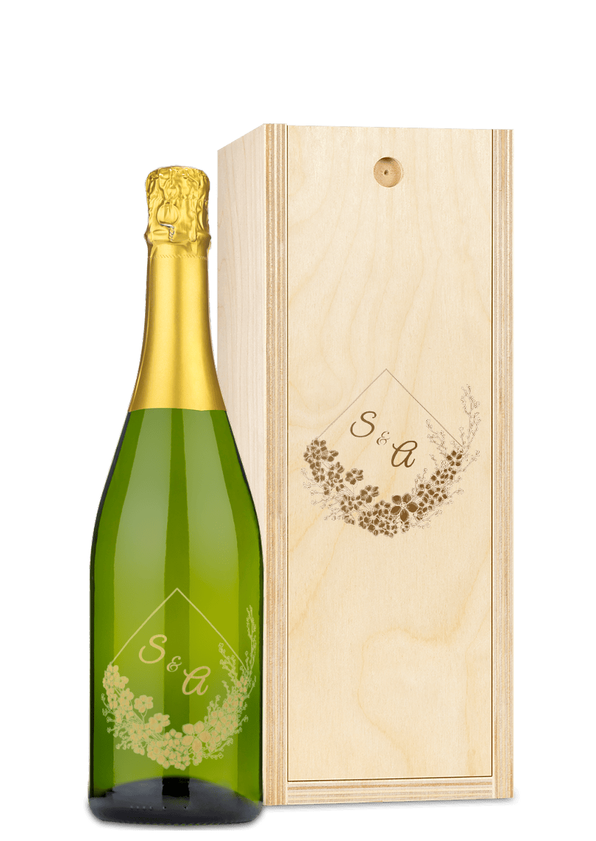 Wine bottle with gold floral “S & A” design alongside a matching engraved wooden box.