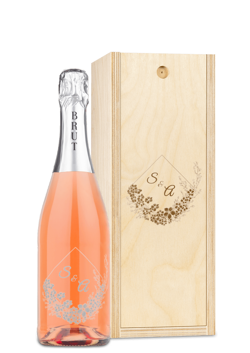 A wooden wine box with custom engraving, holding a bottle of rosé sparkling wine with a personalized label.
