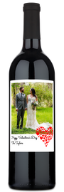 Personalized wine bottle with a custom label featuring a bride, groom, red hearts, and two names.