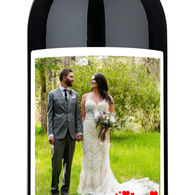 Personalized wine bottle with a custom label featuring a bride, groom, red hearts, and two names.
