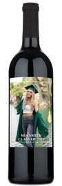 A wine bottle with a graduation-themed label for Mia Smith 2025, displayed in a photo frame with a gold tassel.
