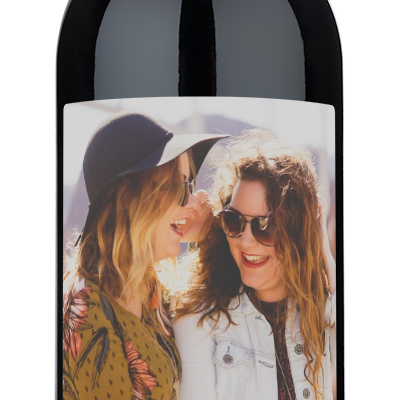 Wine bottle with a label showing two smiling women and the text, Jenn, will you be my bridesmaid?.
