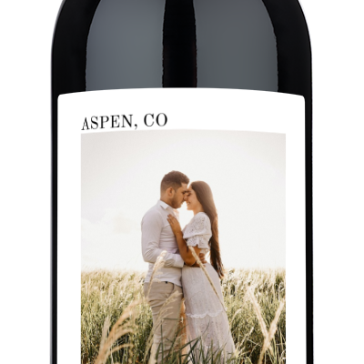 A wine bottle with a label showing a couple kissing, their names Addie & Jason, and Aspen, CO 12.12.25 printed below.