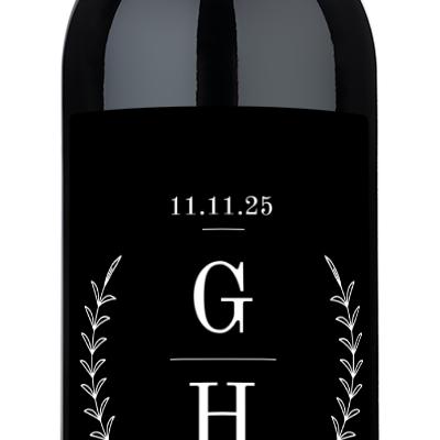 A wine bottle featuring a monogram label with laurel branches, conveying an elegant, nature-inspired design.