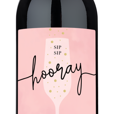 Wine bottle with a pink label displaying names, a date, and an illustration of a champagne glass.