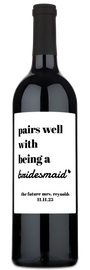 A wine bottle with a label reading Pairs Well With Being a Bridesmaid, personalized for the future Mrs. Reynolds.