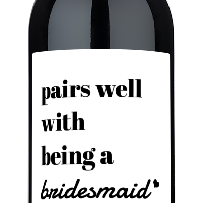 A wine bottle with a label reading Pairs Well With Being a Bridesmaid, personalized for the future Mrs. Reynolds.