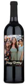 Personalized wine bottle with a label showing three women and the text “Happy Birthday XOXO.”.
